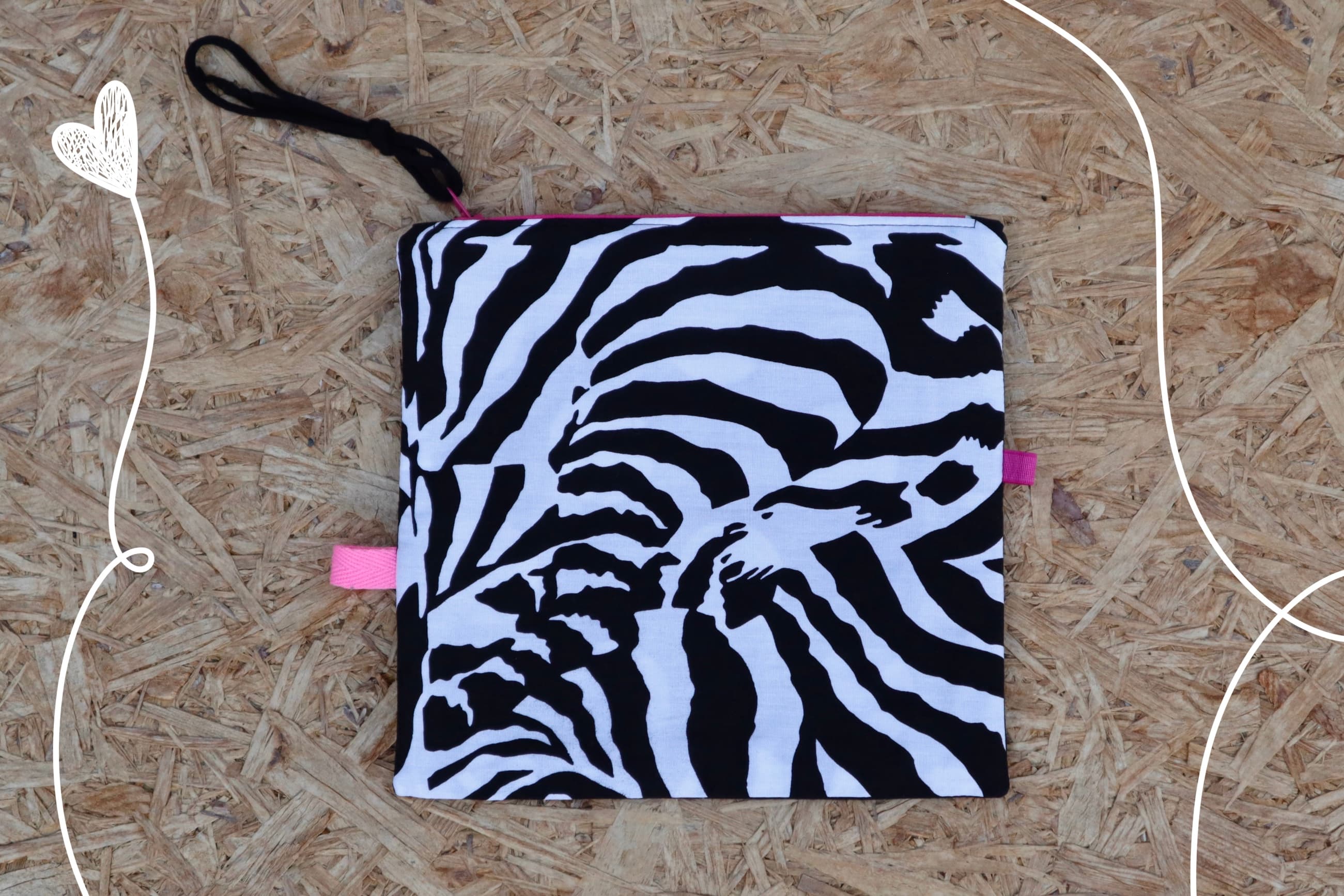 Platneni neseser zebrastog motiva. Sa detaljima roze.